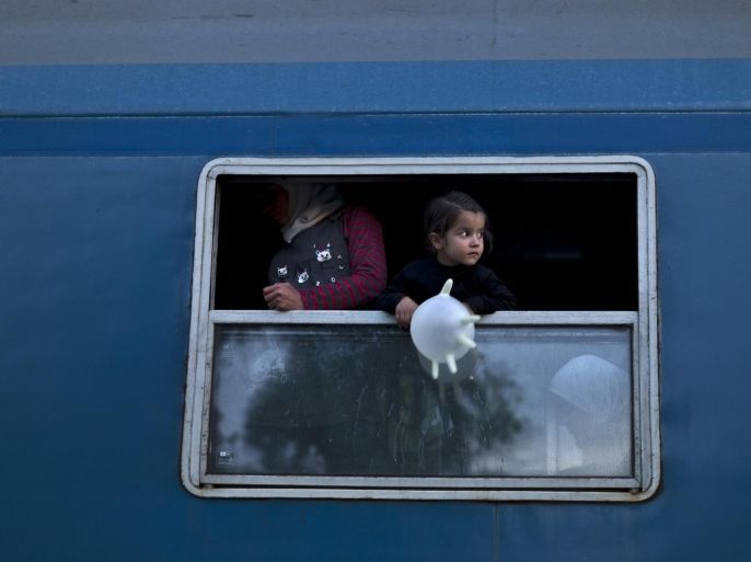 A Syrian refugee child holds a balloon fashioned from a glove while waiting with her family in a train heading for the Austrian border, in Roszke, southern Hungary, Monday, Sept. 14, 2015. Hungary is set to introduce much harsher border controls at midnight — laws that would send smugglers to prison and deport migrants who cut under Hungary's new razor-wire border fence. The country's leader was emphatically clear that they were designed to keep the migrants out. (AP Photo/Muhammed Muheisen)
