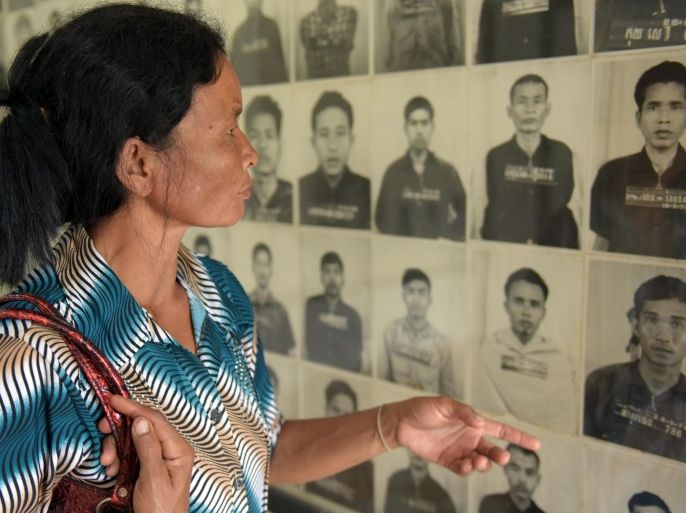A Cambodian woman looks at portraits of victims of the Khmer Rouge displayed at the Tuol Sleng genocide museum in Phnom Penh on August 24, 2015. The former 'first lady' of Cambodia's murderous Khmer Rouge regime died on August 22, according to a UN-backed tribunal, without victims ever seeing her face trial on charges of genocide and crimes against humanity. AFP PHOTO / TANG CHHIN SOTHY