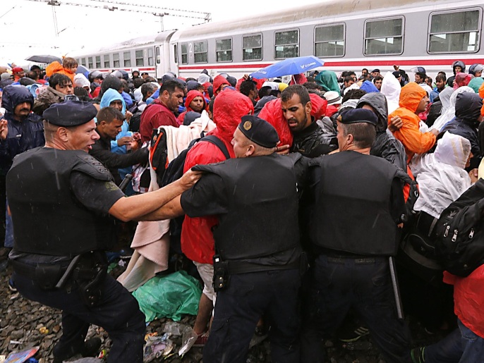الشرطة الكرواتية تحاول إبعاد لاجئين عن القطارات المتجهة إلى النمسا والمجر أمس الأحد (الأوروبية)