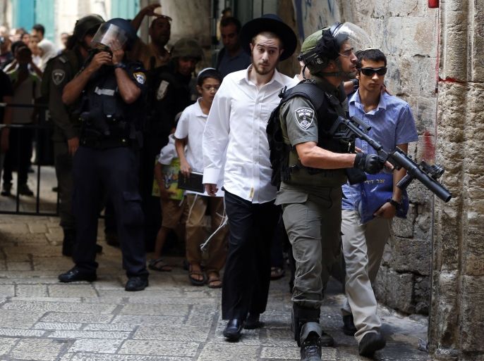 Israeli police stand guard and protect Jewish people as Palestinian demonstraters throw stones in a street of the Muslim quarter in Jerusalem's Old City during scuffles with Israeli riot police on September 15, 2015. Muslims and Israeli police clashed at Jerusalem's flashpoint Al-Aqsa mosque compound for a third straight day as Jews celebrated their new year and protesters vowed to protect Islam's third-holiest site. AFP