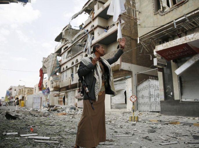 A Shiite fighter known as a Houthi stands guard in front of buildings destroyed by a Saudi-led airstrike in Sanaa, Yemen, Saturday, Sept. 5, 2015. (AP Photo/Hani Mohammed)