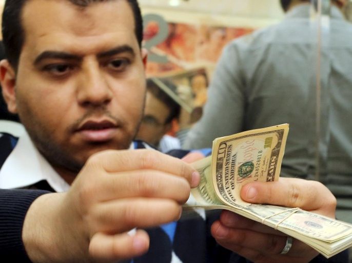 An employee counts money in a foreign exchange office in central Cairo, April 15, 2015. Egypt's central bank kept the pound steady at 7.53 to the dollar at a foreign exchange auction on Wednesday, while the currency remained steady on the black market. Picture taken April 15, 2015. REUTERS/Asmaa Waguih