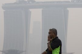 A man covers his nose during a hazy day in Singapore, Thursday, Sept. 10, 2015. Air pollution in Singapore reached its highest level in a year on Thursday as smog from Indonesian forest fires shrouded the island nation in a veil of gray, irking tourists and alarming authorities with hours left before general elections. (AP Photo/Ng Han Guan)