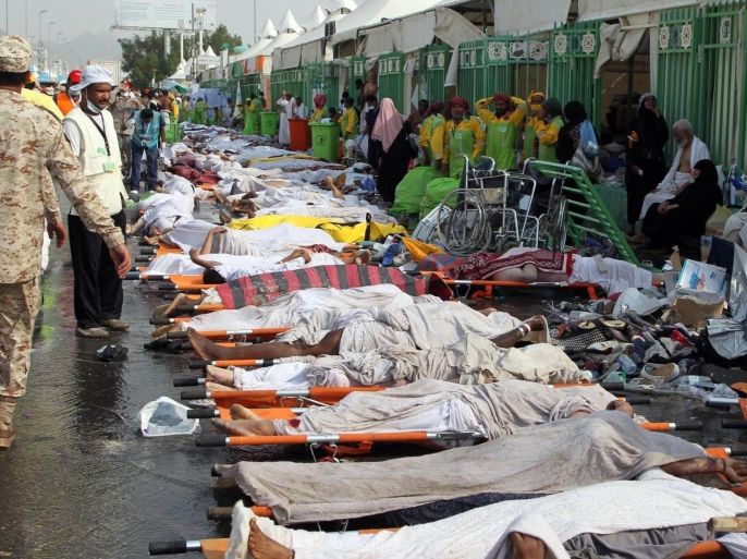 GRAPHIC CONTENT Saudi emergency personnel stand near bodies of Hajj pilgrims at the site where at least 717 were killed and hundreds wounded in a stampede in Mina, near the holy city of Mecca, at the annual hajj in Saudi Arabia on September 24, 2015. The stampede, the second deadly accident to strike the pilgrims this year, broke out during the symbolic stoning of the devil ritual, the Saudi civil defence service said. AFP PHOTO / STR