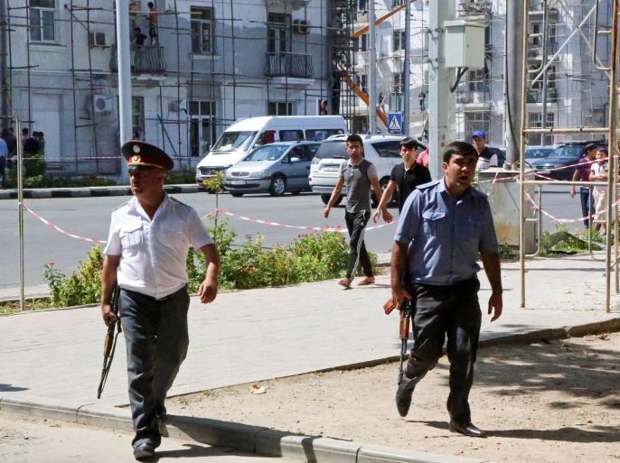 Police officers secure an area in the capital of Tajikistan, Dushanbe, where several Interior Ministry special forces officers and a traffic policeman were reportedly shot dead earlier on Friday, Sept. 4, 2015. Armed groups led by a disaffected deputy defense minister mounted attacks Friday in and near the capital of Tajikistan that left at least eight police officers and nine militants dead, authorities said. (AP Photo/Peter Leonard)