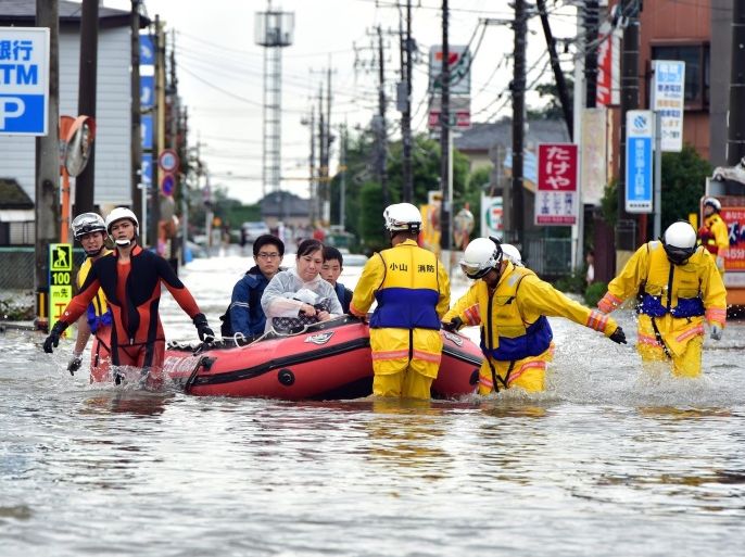Rescue workers transport evacuees in a rubber boat through floodwaters at Oyama in Tochigi prefecture, north of Tokyo on September 10, 2015. Authorities in central Japan ordered tens of thousands to flee their homes after torrential rains flooded rivers and triggered landslides, with one person missing after a mudslide buried houses. The Japan Meteorological Agency issued special downpour warnings for Tochigi and Ibaraki prefectures, north of Tokyo, urging vigilance against mudslides and flooding. AFP PHOTO / Yoshikazu TSUNO