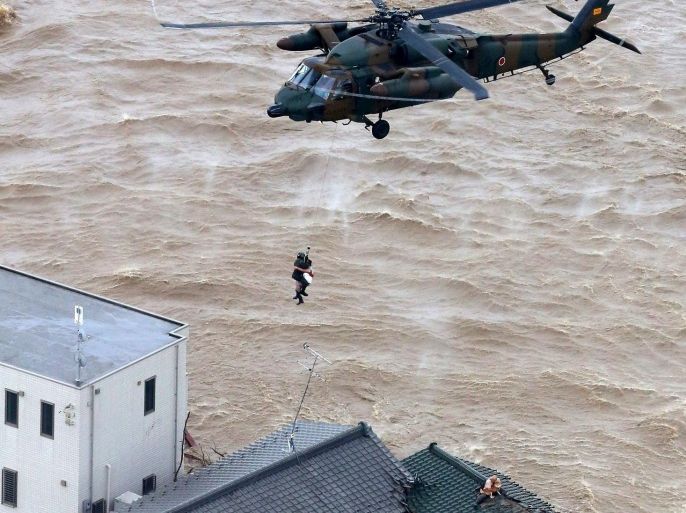 A resident is rescued from a flooded residential area in Joso, Ibaraki prefecture, northeast of Tokyo Thursday, Sept. 10, 2015. Heavy rain is pummeling Japan for a second straight day, overflowing rivers and causing landslides and localized flooding in the eastern part of the country. (Kyodo News via AP) JAPAN OUT, MANDATORY CREDIT