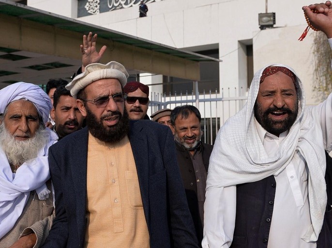 Pakistani Federal Minister for Religious Affairs from the Pakistan Muslim League Nawaz (PML-N), Sardar Yousuf (L) and lawmakers and employees chant slogans against the printing of satirical sketches of the Prophet Muhammad by French magazine Charlie Hebdo outside the Parliament House building in Islamabad on January 15, 2015. Pakistan's parliament on January 15 passed a symbolic resolution condemning as 'blasphemous' the printing of satirical sketches of the Prophet Muhammad by a French magazine, with lawmakers later staging a protest outside the assembly building. The resolution comes after the government officialy condemned the murder of 12 people at the offices of the Charlie Hebdo magazine as a 'brutal terror attack'. AFP PHOTO/ Aamir QURESHI