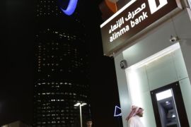 A Saudi man passes by a bank near the kingdom tower Sunday, June 14, 2015, in Riyadh, Saudi Arabia. Saudi Arabia's $585 billion stock market is opening up to direct foreign investment for the first time in its history on June 15. (AP Photo/Hasan Jamali)