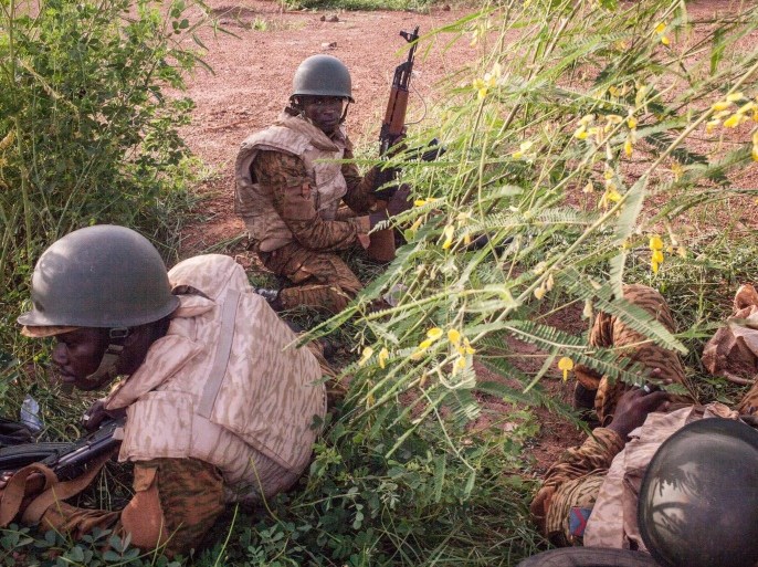 Burkina Faso government soldiers take cover as they patrol a suburb taking control from the soldiers that took part in a coup in Ouagadougou, Burkina Faso, on Tuesday, Sept. 29, 2015. Burkina Faso's army stepped up the pressure Tuesday against those behind last week’s short-lived coup, surrounding the barracks of coup plotters and arresting a former high-ranking minister accused of collaborating with the mutinous soldiers. (AP Photo/Theo Renaut)
