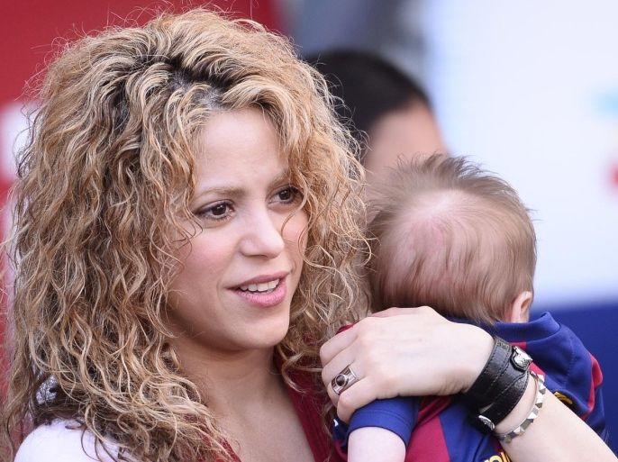 FILE - In this April 18, 2015 file photo, Colombian singer Shakira holds her son Sasha prior to a Spanish La Liga soccer match between FC Barcelona and Valencia at the Camp Nou stadium in Barcelona, Spain. On Wednesday, July 29, Shakira posted on Twitter and Facebook a video titled "Happy 6 months Sasha!" in which she appears holding Sasha in front of a soccer ball. The child raised his leg and gently kicked the ball. (AP Photo/Manu Fernandez, File)