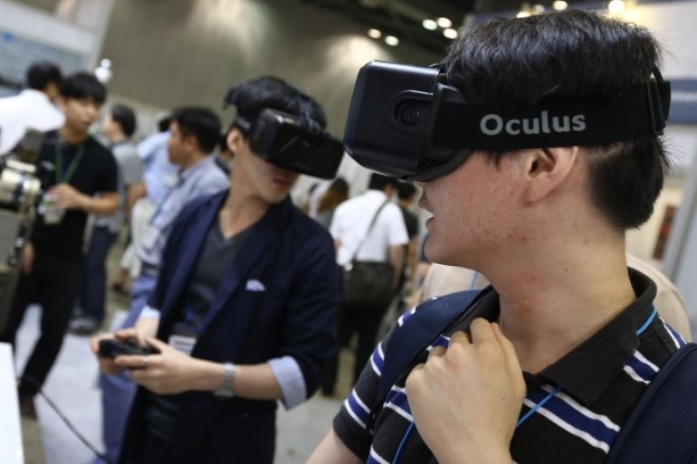 Attendees wearing the Oculus VR Inc. Rift headset play video games at the RoboUniverse Conference &amp; Expo in Goyang, South Korea, on Wednesday, June 24, 2015. The robotics conference and exposition runs through June 26.
