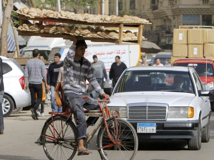 An Egyptian bread vendor rides his bicycle in downtown Cairo, Egypt, Saturday, March 16, 2013. Owners of state-subsidized bakeries protested Saturday against changes to the distribution system of subsidized wheat. It comes amid economic reforms the government is seeking to implement to boost the economy and ensure subsidized bread reaches millions of poor Egyptians who complain that the bakeries sell the wheat for a profit.