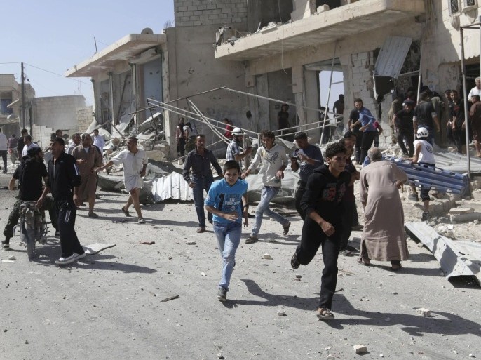 Civilians rush away from a site hit by what activists said was an airstrike by forces loyal to Syria's President Bashar al-Assad, in Kafruma village in the southern countryside of Idlib, Syria September 24, 2015. An internet cafe was was hit during the airstrike, killing several children, activists said. REUTERS/Khalil Ashawi