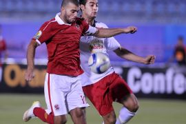 SUEZ, EGYPT - JULY 25: Emad Moteb of Al-Ahly (L) in action against Ammar Al Gamal of Etoile Sportive du Sahel (R) during the Confederation of African Football (CAF) Confederation Cup match between Etoile Sportive du Sahel and Al-Ahly at Suez Stadium in Suez, Egypt on July 25, 2015.