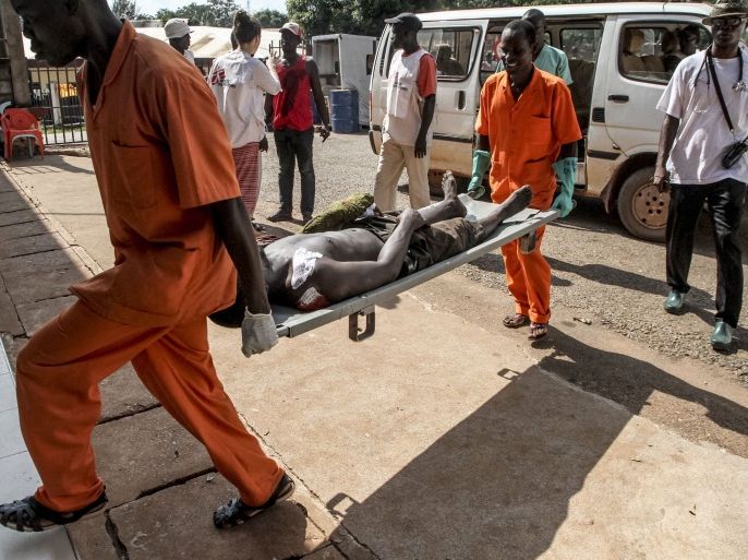 CAR026 - Bangui, -, CENTRAL AFRICAN REPUBLIC : A wounded man is carried into the General Hospital in Bangui on September 26, 2015 after unknown assailants opened fire in the PK5 district, a neighbourhood with a majority of Muslim residents. Security remains fragile in the Central African Republic, which exploded into sectarian violence following a 2013 coup that pitted mainly Muslim rebels against Christian militias. AFP PHOTO / EDOUARD DROPSY