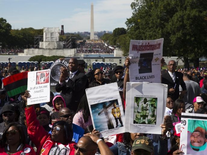People cheer during a rally to mark the 20th anniversary of the Million Man March, on Capitol Hill, on Saturday, Oct. 10, 2015, in Washington. Waving flags, carrying signs and listening to speeches and songs, the crowd gathered at the U.S. Capitol and spread down the Mall under on a sunny and breezy fall day. (AP Photo/Evan Vucci)