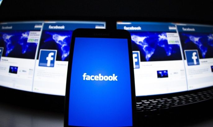 The loading screen of the Facebook application on a mobile phone is seen in this photo illustration taken in Lavigny May 16, 2012. Facebook is trying to lure skeptical advertisers in India, one of its biggest but also hardest to crack markets in the world, with tactics like free email support for questions about advertising and advice on increasing sales for businesses. REUTERS/Valentin Flauraud/Files