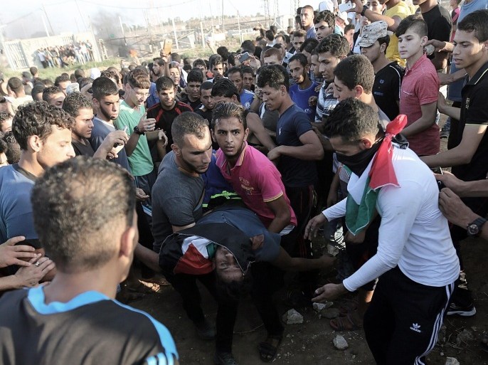 Palestinian youths carry a wounded fellow protester during clashes with Israeli troops at the Nahel Oz border in the east of the Al Shejaeiya neighbourhood in eastern Gaza City, Gaza Strip, 09 October 2015. At least five Palestinian youths were killed during clashes with Israeli troops along the border between Israel and the eastern Gaza Strip, media reports said.