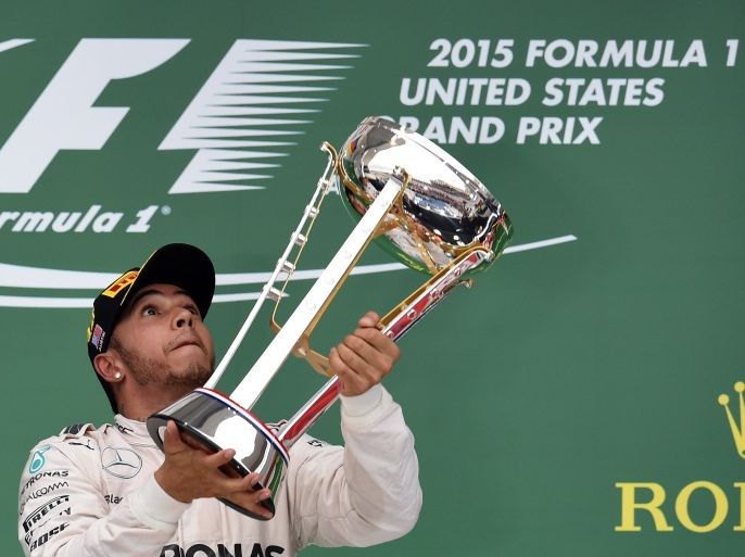 JS3503 - Austin, Texas, UNITED STATES : Mercedes AMG Petronas British driver Lewis Hamilton celebrates with his trophy on the podium after winning the US Formula One Grand Prix at the Circuit of The Americas in Austin, Texas, on October 25, 2015. Hamilton won a third Formula One world title on Sunday when he swept to victory in the United States Grand Prix. AFP PHOTO/JEWEL SAMAD