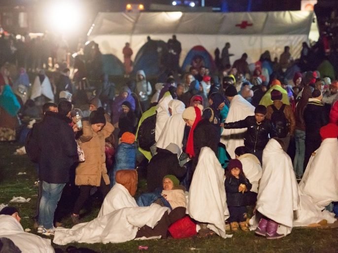 Refugees wait to travel further at the border between Germany and Austria near Wegscheid, Germany, 28 October 2015. Recent spats between the neighbours Germany and Austria have flared into a blazing row over refugees. German federal police is continously struggling with a major influx of refugees.