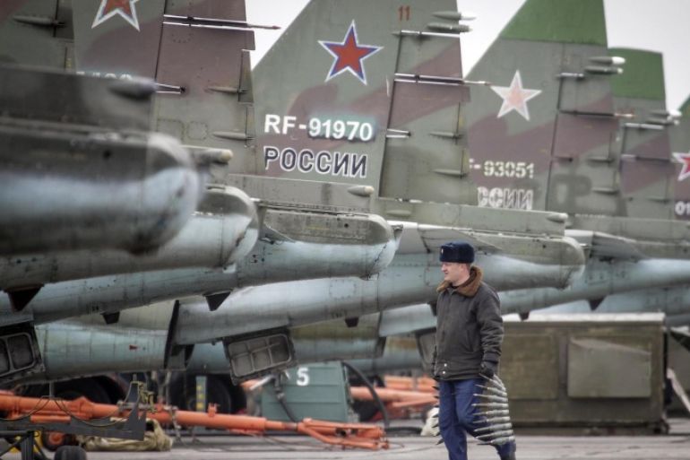 A serviceman carries ammunition next to Sukhoi Su-25 jet fighters during a drill at the Russian southern Stavropol region, March 12, 2015. Russia has started military exercises in the country's south, as well as in Georgia's breakaway regions of South Ossetia and Abkhazia and in Crimea, annexed from Ukraine last year, news agency RIA reported on Thursday, citing Russia's Defence Ministry. REUTERS/Eduard Korniyenko (RUSSIA - Tags: POLITICS CIVIL UNREST MILITARY)