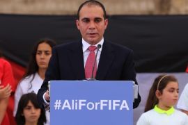 Jordan's Prince Ali bin al-Hussein, flanked by school-age soccer players in uniforms, speaks before about 300 guests during an event at a Roman amphitheater in Amman, Jordan, Wednesday, Sept. 9, 2015. The prince is running for FIFA president, saying Wednesday he will fight "deep-seated corruption and political deal-making" and make soccer's scandal-scarred governing body more transparent. (AP Photo/Raad Adayleh)