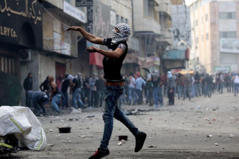 A Palestinian protesters throws stones during clashes with members of the Israeli armed forces in the West Bank city of Hebron, 09 October 2015. Israeli soldiers killed four Palestinians in clashes on the border with the Gaza Strip, while there were four stabbing incidents inside Israel targeting both Jews and Palestinians. Violence has been ongoing for weeks, focused on Jerusalem and nearby areas on the West Bank amid rising concerns the situation could lead to an even greater escalation if not scaled back soon.