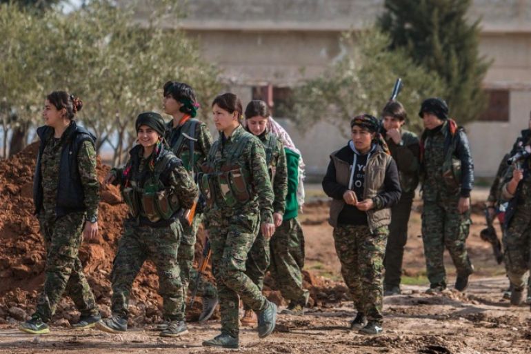 FILE - In this May 16, 2015 file photo released by the Kurdish fighters of the People's Protection Units (YPG), which has been authenticated based on its contents and other AP reporting, Kurdish female fighters of the YPG carry their weapons as they walk in the frontline of Kery Sabee village, northeastern Syria. U.S.-backed Kurdish forces have forcefully displaced thousands of Syrian civilians, mostly Arabs, and demolished villages in northern Syria, often in retaliation for the residents' perceived sympathies for the Islamic State group and other militants, Amnesty International said Tuesday, Oct. 13. (The Kurdish fighters of the People's Protection Units via AP, File)