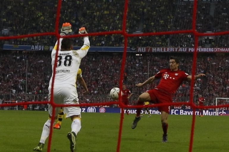 Bayern Munich's Robert Lewandowski (R) scores a goal against Borussia Dortmund during their German first division Bundesliga soccer match in Munich, Germany, October 4, 2015. REUTERS/Michaela Rehle DFL RULES TO LIMIT THE ONLINE USAGE DURING MATCH TIME TO 15 PICTURES PER GAME. IMAGE SEQUENCES TO SIMULATE VIDEO IS NOT ALLOWED AT ANY TIME. FOR FURTHER QUERIES PLEASE CONTACT DFL DIRECTLY AT + 49 69 650050.