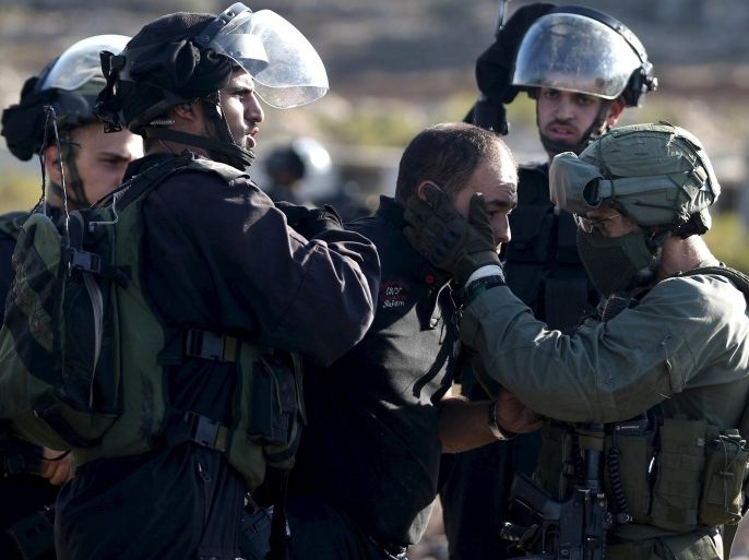 Israeli policemen detain a Palestinian protester during clashes near the Jewish settlement of Bet El, near the West Bank city of Ramallah, October 11, 2015. Four Israelis and 23 Palestinians have died in 12 days of bloodshed fueled in part by Muslim anger over increasing Jewish access to the al-Aqsa mosque compound in Jerusalem. Violence has spread from the holy city and the Israeli-occupied West Bank to Israel's interior and Hamas-ruled Gaza. REUTERS/Mohamad Torokman