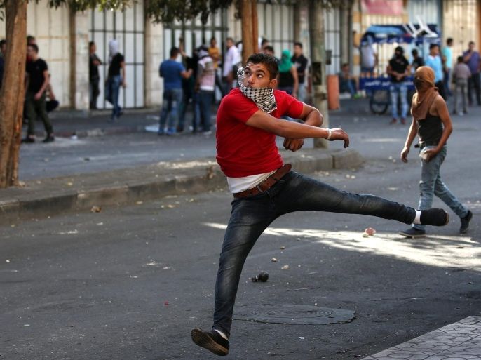 Palestinian protesters throw stones during clashes in the West Bank city of Hebron, 21 October 2015. United Nations Secretary General Ban Ki-moon says he understands Palestinian frustrations, but urges violence will not help achieve statehood. In a surprise emergency visit to the region, Ban urged Palestinians to stop knife attacks and violent protests, and Israel to stop security measures such as demolishing homes and erecting walls, acts that he warned would only add to Palestinian desperation and frustration.
