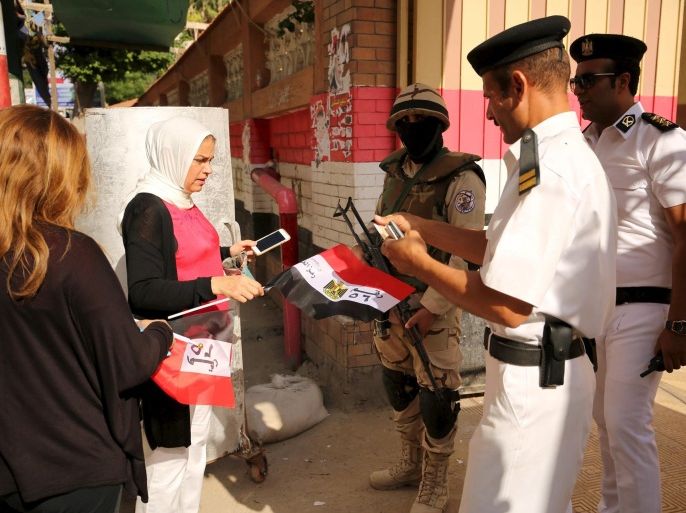 Police ask women to fold their flags before allowing them into a school used as voting centre in Alexandria, Egypt, October 18, 2015. Many Egyptian voters shunned the first phase of a parliamentary election on Sunday that President Abdel Fattah al-Sisi has hailed as a milestone on the road to democracy but his critics have branded as a sham. REUTERS/Asmaa Waguih