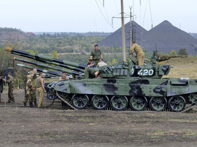In this photo taken on Monday, Sept. 21, 2015 Russia-backed separatists refuel tanks in a field near Torez, eastern Ukraine. The Ukrainian government said on Thursday, Oct. 1, 2015, it will pull out small-caliber weapons from the war-torn east in two days' time if the cease-fire holds. A military conflict between government forces and Russia-backed separatists in eastern Ukraine has been raging since April 2014, leaving more than 8,000 people dead and 2 million displaced. (AP Photo/Anton Volk)