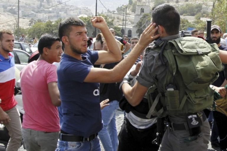 An Israeli border policeman exchanges blows with a Palestinian man during a confrontation after Friday prayers outside the Old City in Jerusalem Friday, Oct. 2, 2015. Tensions have continued to flare between Israelis and Palestinians over the Jerusalem site known to Jews as the Temple Mount, home to the biblical Temples, and to Muslims as the Noble Sanctuary, site of the Al-Aqsa mosque and the spot from where the Prophet Muhammad is said to have ascended to heaven. (AP Photo/Mahmoud Illean)