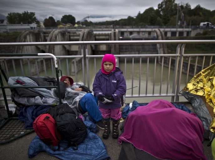 In this photo taken on Thursday, Sept. 24, 2015, Syrian refugee Abdulwahab Alabdullah, 5, who came with his family from Aleppo, Syria, poses for a picture while waiting on a bridge after they spent the night waiting for their registration and transport by German police to a refugee shelter in Freilassing, Germany. "I am so cold waiting with my father and mother and younger brother from two days in this bridge," he said. (AP Photo/Muhammed Muheisen)