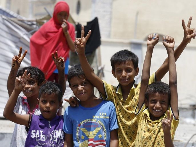 Children gesture for the camera in Yemen's southern port city of Aden September 27, 2015. As Gulf-backed forces assemble in Marib province east of Sanaa ahead of a widely expected thrust towards the Houthi-held capital, the fate of Aden and its hinterland may offer a glimpse at whether some form of central government can be resurrected. To match Insight YEMEN-SECURITY/ADEN REUTERS/Faisal Al Nasser