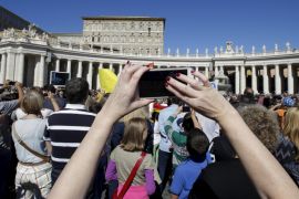 A faithful takes pictures during the Angelus prayer led by Pope Francis in Saint Peter's square at the Vatican, October 11, 2015. REUTERS/Max Rossi