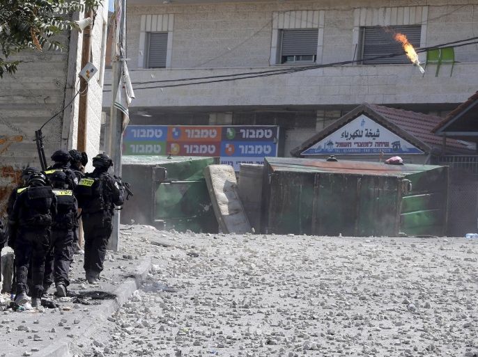Israeli police officers move towards Palestinian protesters as a molotov cocktail is thrown during clashes in the East Jerusalem neighbourhood of Issawiya October 4, 2015. A Palestinian man stabbed and killed two Israelis in Jerusalem's Old City on Saturday before police shot him dead, officers said, amid an uptick in violence in the city and occupied West Bank. According to local media, the two men who were killed were identified as Nehemia Lavi, 41, of Jerusalem and Aharon Bennett, 21, of Beitar Illit. REUTERS/Ammar Awad