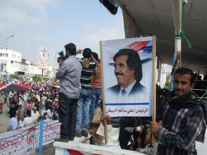ناشط يرفع صورة علي سالم البيض زعيم الحراك الجنوبي المطالب بانفصال جنوب اليمن عن شماله، خلال احتفال بذكرى ثورة 14 أكتوبر،