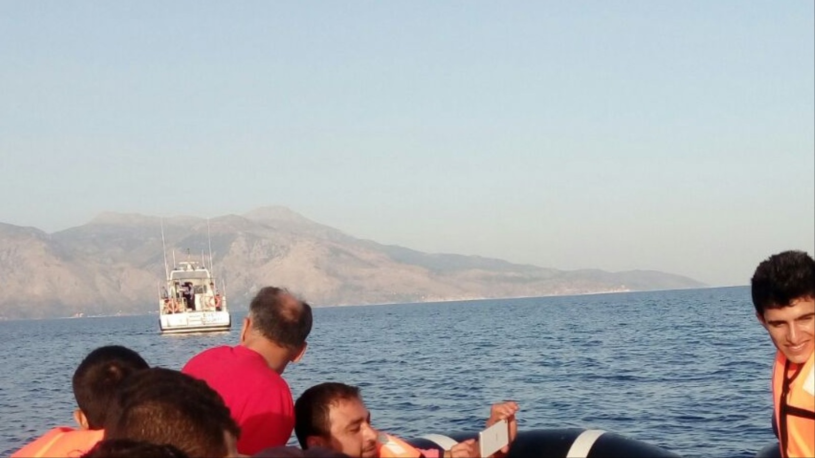 لاجئ سوري يلتقط صورة (سيلفي) في عرض بحر إيجة الفاصل بين الشواطئ التركية واليونانية(الجزيرة)