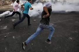 Palestinian protesters run for cover from tear gas fired by Israeli troops during clashes near the Jewish settlement of Bet El, near the West Bank city of Ramallah October 23, 2015. Palestinian factions called for mass rallies against Israel in the occupied West Bank and East Jerusalem in a "day of rage" on Friday, as world and regional powers pressed on with talks to try to end more than three weeks of bloodshed. REUTERS/Mohamad Torokman