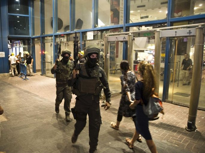 Israeli special forces walk out of the Central Jerusalem Bus Station after police said a woman was stabbed by a Palestinian outside the bus station October 14, 2015. A Palestinian stabbed and moderately wounded a 70-year-old woman outside Jerusalem's central bus station, at the entrance to the city, before an officer shot him dead, a police spokeswoman said. Israel began setting up roadblocks in Palestinian neighbourhoods in East Jerusalem and deploying soldiers across the country on Wednesday to stop a wave of Palestinian knife attacks. Seven Israelis and 32 Palestinians killed in violence, including children and assailants, have been killed in two weeks of bloodshed in Israel, Jerusalem and the occupied West Bank. REUTERS/ Ronen Zvulun