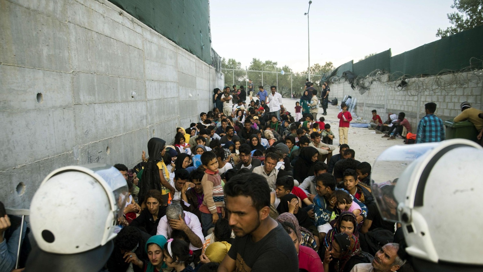 ‪لاجئون أفغان ينتظرون عمليات التسجيل في الجزر اليونانية‬ (رويترز)