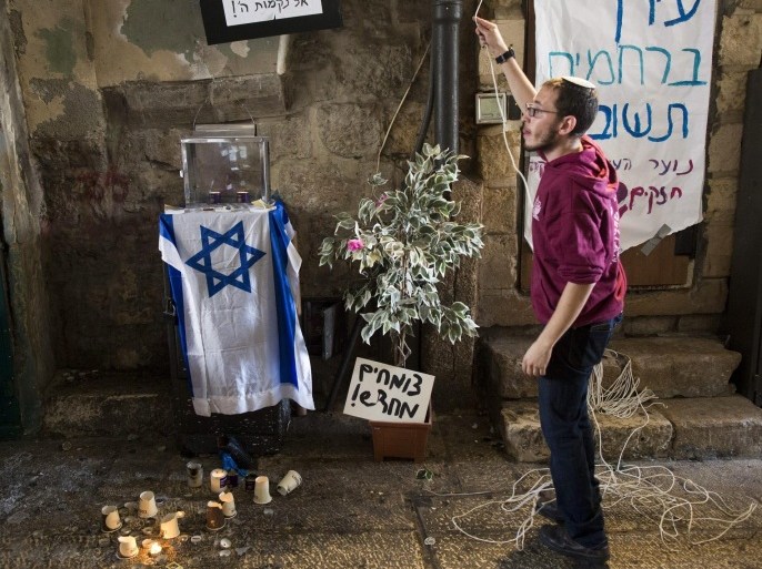 A right-wing Israeli man stands near candles at the scene after an attack involving a Palestinian woman and Israeli man in the Old City of Jerusalem, Israel, 07 October 2015. According to Israeli police, the man was carrying a gun and shot the woman after she attacked him with a knife - both were hospitalized. There have been increasing clashes in recent weeks between Israelis and Palestinians amid a rift over the use of the flashpoint site called the Temple Mount by Jews and the Noble Sanctuary by Muslims, which lies in Jerusalem's Old City.