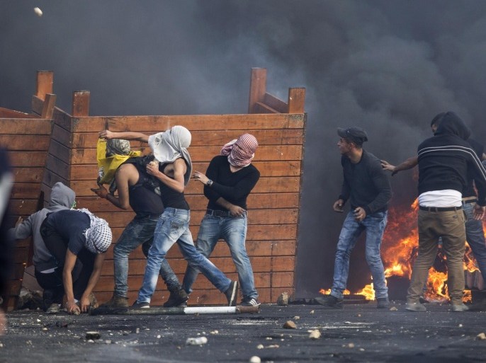 Palestinian protesters throw stones, during clashes with Israeli troops near Ramallah, West Bank, Friday, Oct. 9, 2015. Recent days have seen a string of attacks by young Palestinians with no known links to armed groups who have targeted Israeli soldiers and civilians at random, complicating Israeli efforts to contain the violence, which has been linked to tensions over a sensitive Jerusalem holy site. (AP Photo/Majdi Mohammed)