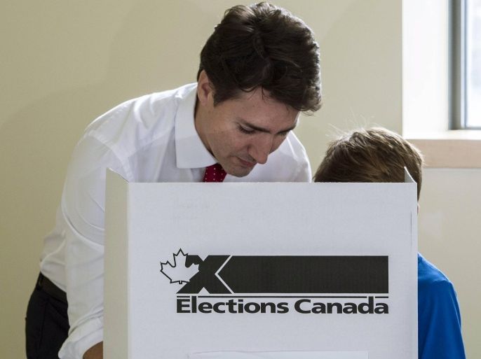 Liberal leader Justin Trudeau marks his ballot accompanied by his son Xavier in Montreal, Quebec, October 19, 2015. Canadians go to the polls in a federal election on Monday. REUTERS/Paul Chiasson/Pool
