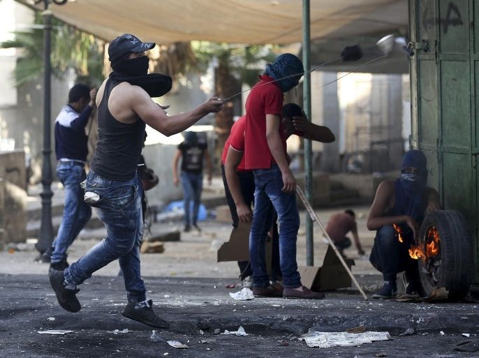 Palestinian protesters throw stones during clashes in the West Bank Hebron, 17 October 2015. Israeli army report about two stabbing attacks against soldiers in Hebron earlier today carried out by a Palestine man and woman, both reported killed by the Israeli army.