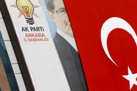 A big Turkish flag partly covers the portrait of Turkish Prime Minister Ahmet Davutoglu hung on an office of Turkey's ruling AK Party (AKP) in Ankara, Turkey, September 12, 2015. When Turkey's ruling AK Party convenes its three-yearly congress in the capital Ankara on Saturday, the longest shadow will be cast by a politician who, officially at least, is no longer even a member: President Tayyip Erdogan. The most popular and divisive Turkish politician in recent memory faces budding discontent from inside the movement he founded, officials say, as his drive to secure an absolute majority for the AKP has pushed it toward a snap election where such a result is uncertain. The friction between Erdogan and the man who replaced him as head of the AKP, Prime Minister Ahmet Davutoglu, is likely to play out on Saturday as both men attempt to stack the party's committees with their own loyalists. REUTERS/Umit Bektas