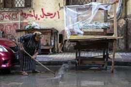 An Egyptian woman clears water from the street after a heavy rainfall in Alexandria, Egypt, Sunday, Oct. 25, 2015. Severe weather swept across the Middle East on Sunday, pounding Israel with baseball-sized hail, sending torrents of uncollected garbage through the streets of Beirut and killing six people in Egypt, five of whom were electrocuted by a fallen power cable. The cable from a tramway landed in streets flooded with water, electrocuting the five, senior health official Magdy Hegazy said. (AP Photo/Heba Khamis)